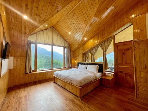 a bedroom with a bed and a large window at The Highgrove House, Manali in Haripūr