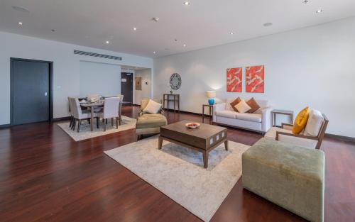 a living room with a couch and a table at Luxe Getaways Royal Amwaj Palm Jumeirah Resort Apartment Holiday Home in Dubai