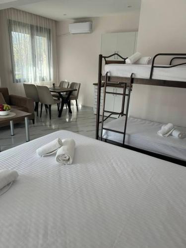 a room with three bunk beds and a table and chairs at Alex Studios Paralia Vrasna in Asprovalta