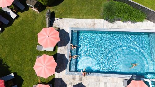 an overhead view of a swimming pool with umbrellas at Hotel Der Wastlhof - Pools, Spa & eigene Reitschule in Niederau