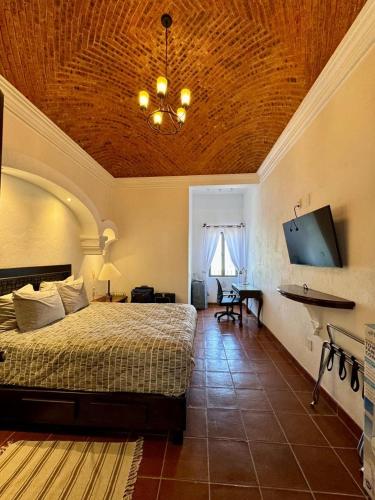 a bedroom with a bed and a chandelier at H san Carlo suite in Guanajuato