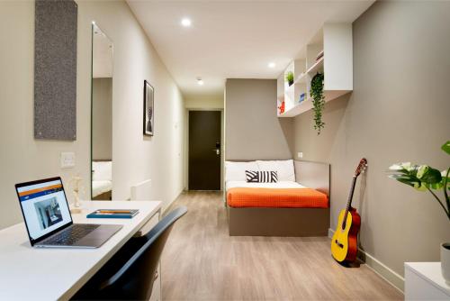 a bedroom with a desk and a bed with a laptop at For Students Only - Saw Mill in Huddersfield in Huddersfield