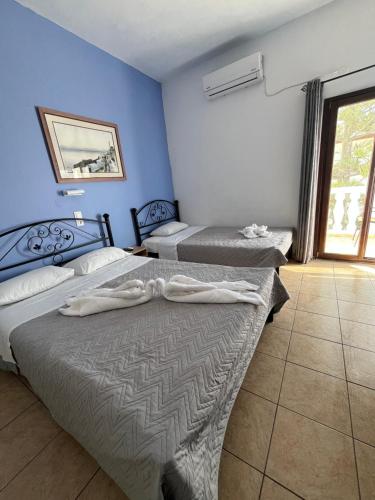two beds in a room with blue walls at Stella Nomikou Apartments in Firostefani