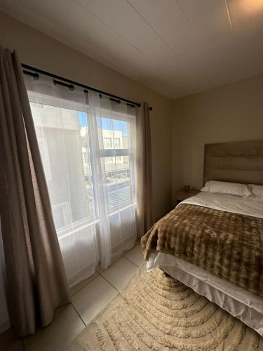a bedroom with a bed and a large window at Ubuntu Escape in Windhoek