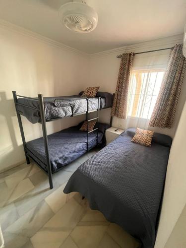 two bunk beds in a room with a window at LAGUNA BEACH PISCINA- HOME RENt MALAGA in Torrox Costa