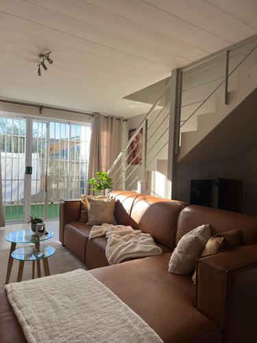 a living room with a brown couch and a table at Ubuntu Escape in Windhoek