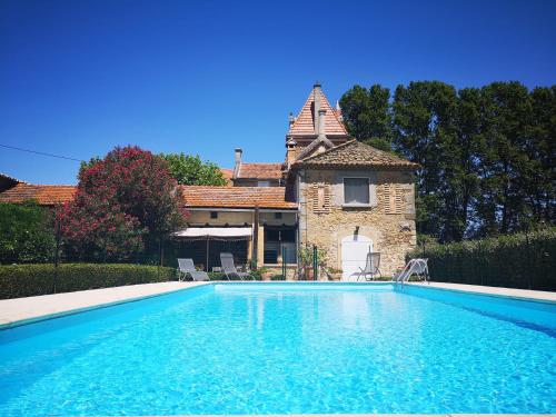 a swimming pool in front of a house at Château Rouge - petit château avec piscine - 8 chambres in Bollène