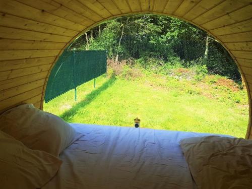 Una tienda de campaña con vista a un campo desde una ventana. en Tonneau bulle insolite, vue sur vignoble, en Pouldergat
