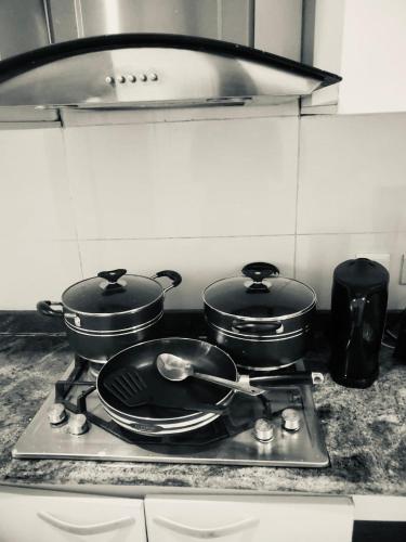 two pots and pans on a stove in a kitchen at Luxury 2bedroom Apt in lekki,24hrs light, Wifi in Lekki