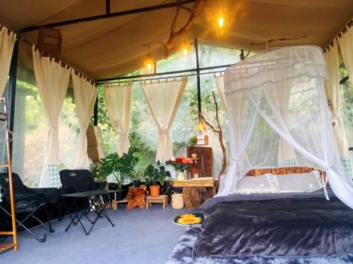 a bedroom with a canopy bed in a tent at Mây Glamping in Xuân Thọ