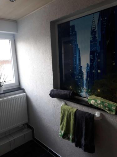 a bathroom with a tv and towels on a shelf at Ferienwohnung in Rositz