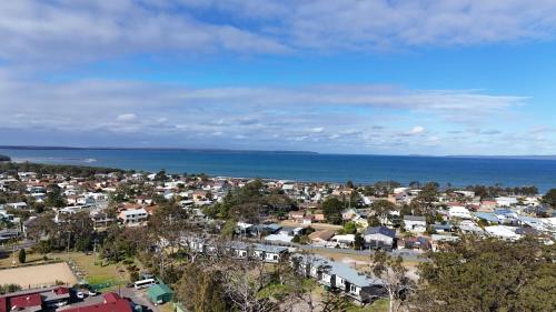 an aerial view of a town next to the ocean at Modern 2 Bed Apartment with BBQ - 6 Min walk to beach in Callala Beach