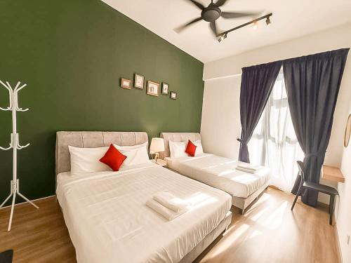 a bedroom with two beds and a green wall at Ipoh The Cove Hillside Stay 7 to 10 pax, 5 min to Ipoh Town in Ipoh