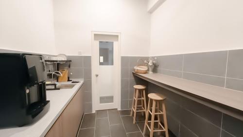 a kitchen with two bar stools and a counter at Ipoh The Cove Hillside Stay 7 to 10 pax, 5 min to Ipoh Town in Ipoh