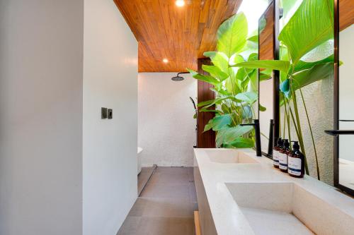a bathroom with two sinks and lots of plants at Cozy Honeymoon 1BR Villa Cempaka LaLuxe A9 Sanur in Sanur