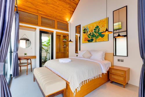 a bedroom with a bed and a desk in a room at Cozy Honeymoon 1BR Villa Cempaka LaLuxe A9 Sanur in Sanur