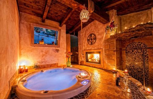 a large bath tub in a room with a fireplace at Il Giardino dei Flintstones B&B in Cerveteri