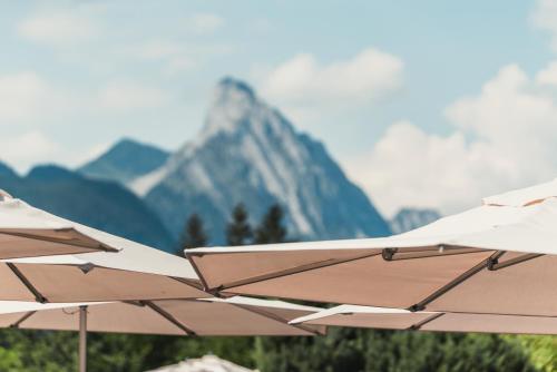 a row of umbrellas in front of a mountain at ERMITAGE Wellness- & Spa-Hotel in Gstaad