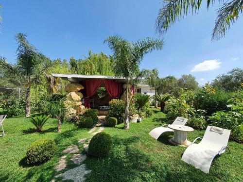 a yard with a house with a table and chairs at Il Giardino dei Flintstones B&B in Cerveteri