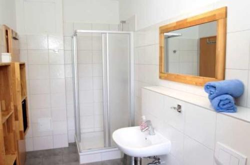 a white bathroom with a sink and a shower at Ferienwohnungen Am Yachthafen in Greifswald