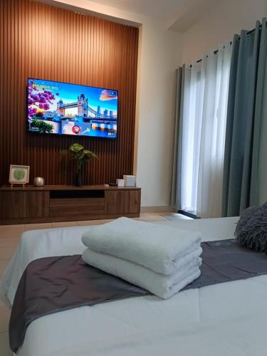 a bedroom with a bed with a flat screen tv at Hill Residences by KJA in Manila