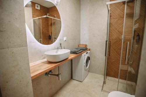a bathroom with a sink and a washing machine at Modern Luxury Apartment & Parking in Leszno