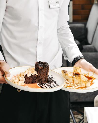 a chef is holding two plates of food at Hotel Diamond in Baku