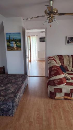 a bedroom with a bed and a couch and a fan at Norbi Vendégház in Balatonszárszó