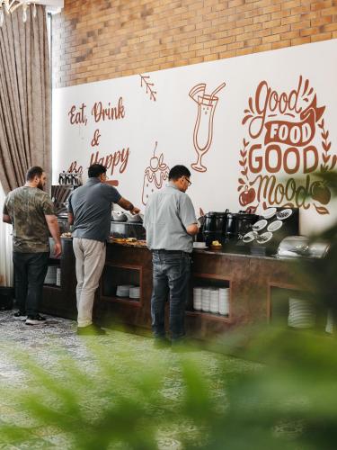 a group of men standing at a counter preparing food at Hotel Diamond in Baku