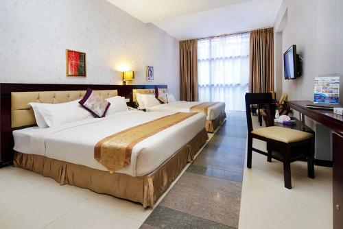 a hotel room with two beds and a desk at The Cox Today Limited in Cox's Bazar