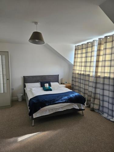 ダートフォードにあるStay in Doubleroom with professionals, Neat, Cosy - Dartford Centralの青い毛布が掛けられたベッドのある寝室