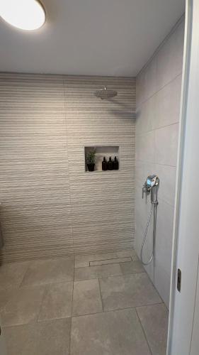 a shower stall in a bathroom with a tile floor at נופש בהגושרים in Hagoshrim