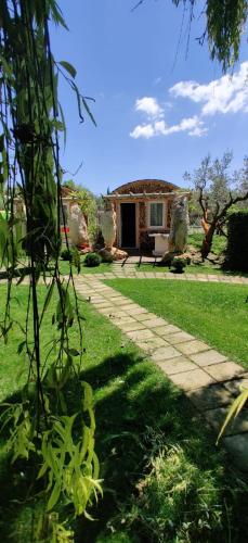 a house with a stone pathway in front of a yard at Il Giardino dei Flintstones B&B in Cerveteri