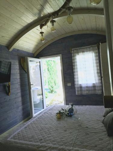a bedroom with a large bed with a large window at Il Giardino dei Flintstones B&B in Cerveteri