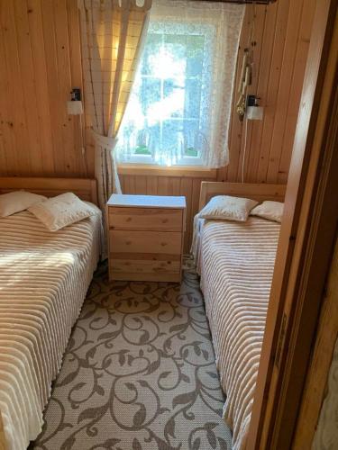two beds in a small room with a window at Яглина in Sprynya