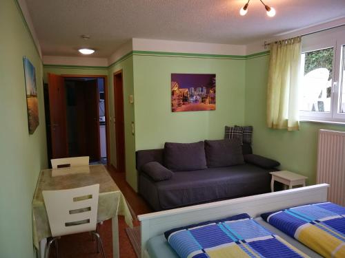 a living room with a couch and a table at Gästezimmer Sieg in Rust