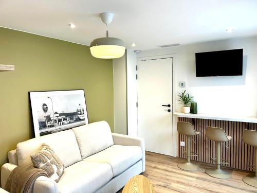 a living room with a couch and a tv at LILLEHOSTS 2, Vieux Lille, Newly renovated, Modern & Stylish apartment, perfectly located in Lille