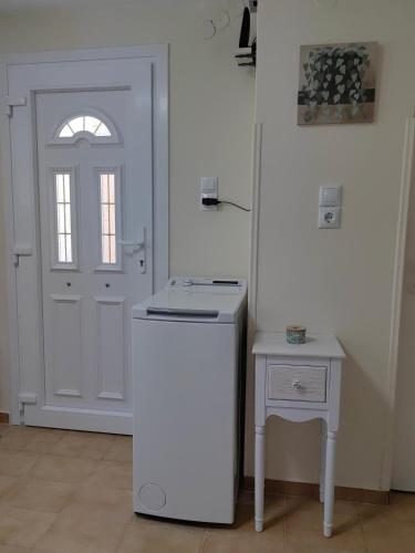 a kitchen with a white refrigerator next to a door at Little Kristi in Palaiókastron