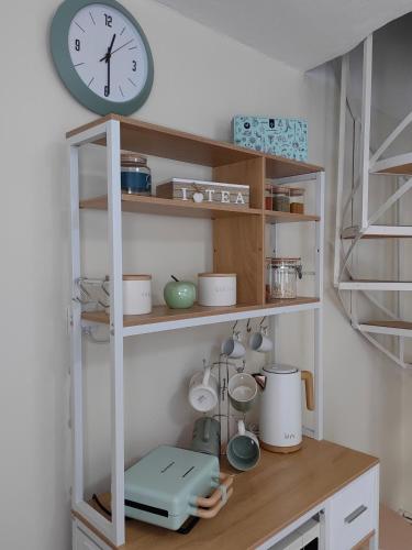 a shelf with a clock on top of it at Little Kristi in Palaiókastron