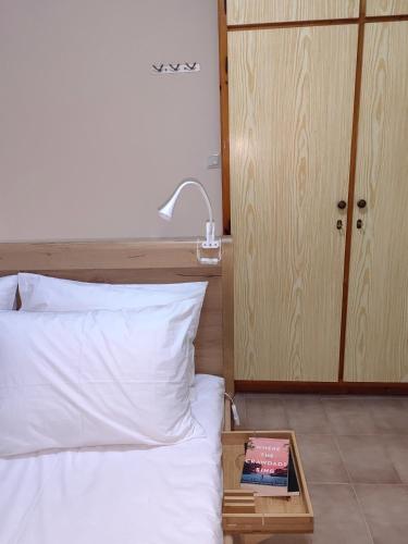 a bed with a tray with a book on it at Little Kristi in Palaiókastron