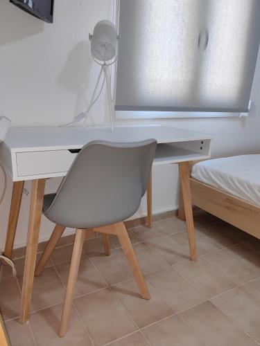 a desk with a chair next to a bed at Little Kristi in Palaiókastron