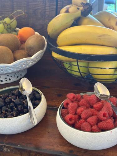 a wooden table with bowls of fruit and spoons at Château De La Bûcherie in Saint-Cyr-en-Arthies