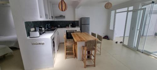 a white kitchen with a wooden table in it at Villa NAIM in Marrakech