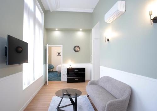 ein Wohnzimmer mit Couch und Fernseher in der Unterkunft Motte Fénelon Appart in Cambrai