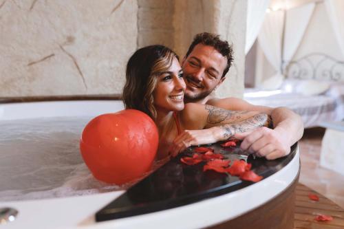 a man and a woman in a bath tub at Il Giardino dei Flintstones B&B in Cerveteri