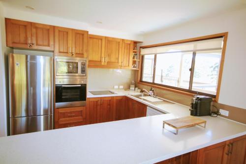 a kitchen with wooden cabinets and a stainless steel refrigerator at Clarendon Forest Retreat in Possum Brush