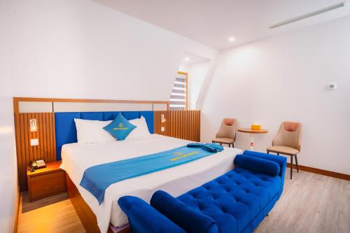 a bedroom with a large bed with a blue couch at Crystal Holiday Ha Long Hotel in Ha Long