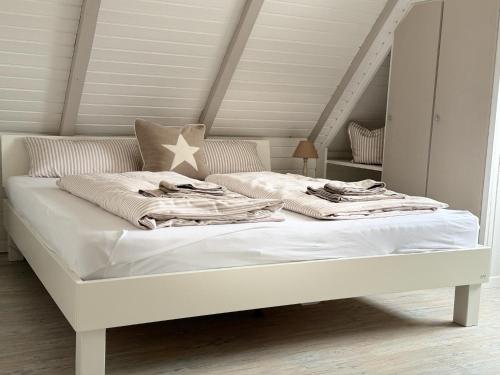 ein weißes Bett mit Decken und einem Stern darauf in der Unterkunft Ferienhaus Berg in Sylt