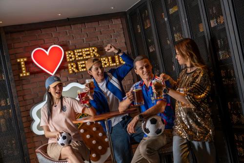 a group of people posing for a picture with beer at Holiday Inn Bangkok by IHG in Bangkok