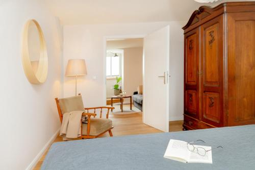 a bedroom with a bed and a chair and a mirror at Apartments am Bahnhof in Stralsund
